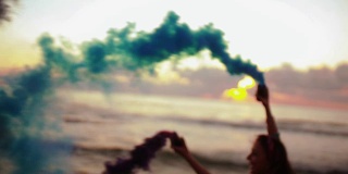 日落时分，年轻女子背着烟雾弹在海滩上奔跑