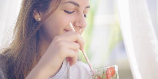 年轻女子喝黄瓜草莓排毒水。