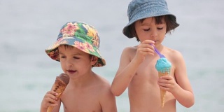 可爱的小孩，男孩兄弟，夏天在海滩上吃冰淇淋