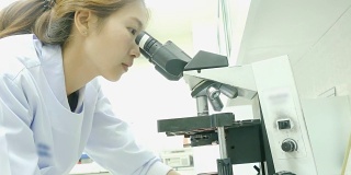 在医院实验室里摆弄显微镜的女科学家技术员
