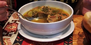 在餐馆里喝羊肉汤的女人。阿塞拜疆国菜Piti汤