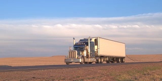 太阳升起时，货运集装箱半挂车在空旷的高速公路上行驶