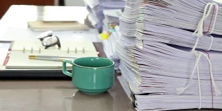 仔细查看办公桌上成堆的文件