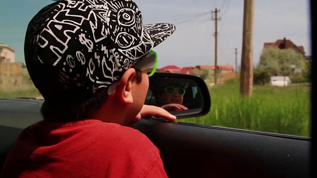 那个戴着帽子和眼镜的男孩从开着的车窗往里看