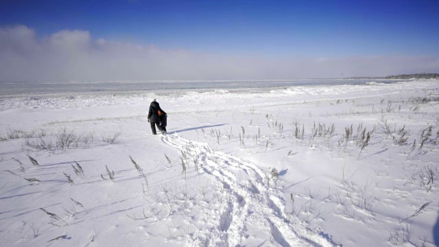 母亲和孩子走在加拿大安大略省乔治亚湾在冬天的雪