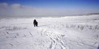 母亲和孩子走在加拿大安大略省乔治亚湾在冬天的雪