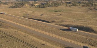 空中摄影:半卡车和汽车在风景优美的乡村丘陵公路上行驶
