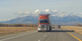 特写:半卡车沿着高速公路行驶，经过农田和牧场