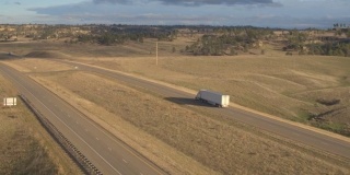 天线:半挂卡车拖着货物沿着空旷的乡村山地公路行驶