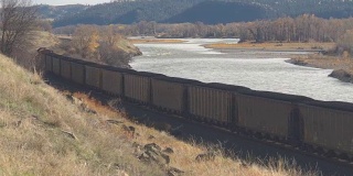近距离观察:满载煤炭的火车通过风景优美的河谷