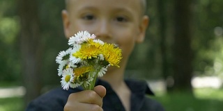 特写的小孩抱着和给予一束花，并提供他们