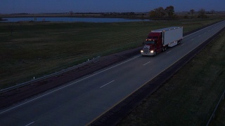 空中摄影:夜间在路上用集装箱运输货物的半挂车视频素材模板下载
