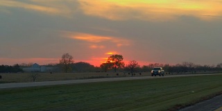 观点:在日出时，开车经过农田，穿过风景如画的乡村