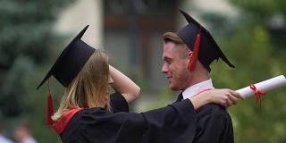 男女朋友拥抱，手里拿着高等学历证书