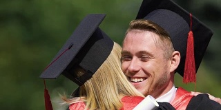 真诚友好的情感在男毕业生拥抱年轻女性的笑脸上