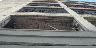 低角度视角:旧废弃工业建筑窗户上的碎玻璃