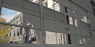 靠近:废弃工厂中破碎的窗户，破损的立面和破碎的墙壁