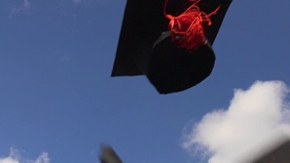戴着学士帽在晴朗的蓝天上飞翔，象征着高等教育，幸福的未来视频素材模板下载
