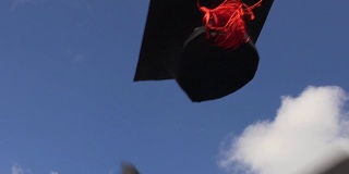 戴着学士帽在晴朗的蓝天上飞翔，象征着高等教育，幸福的未来