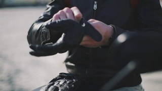 摩托车手戴上手套的特写视频素材模板下载