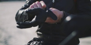 摩托车手戴上手套的特写