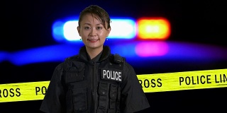 亚裔美国女警察在犯罪现场微笑，背景是警笛