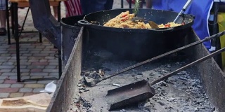 在街头咖啡馆里，一个盛着乌兹别克肉饭的大碗正放在冒烟的炉子上。街头小吃，快餐，街头小吃，好吃，美味