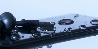 水滴随着耳机落在手机屏幕上。
