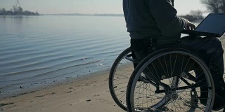 残疾人坐在轮椅上，大自然在河边