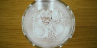 纯碳酸饮用水从一个瓶子俯视图。慢动作