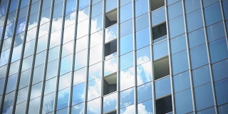 移动的云反射在窗户建筑上