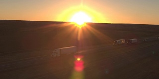 太阳升起时，用空中装载的半卡车在荒芜的国土上运送货物