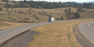 卡车和汽车在高速公路上驶近落基山脉