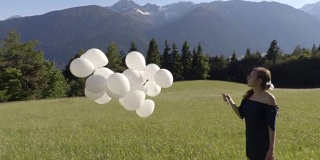 女孩在风中拿着白色的气球