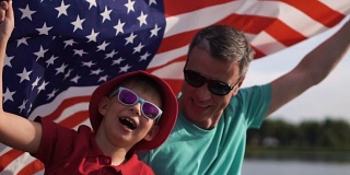 小男孩和他的父亲举着美国国旗