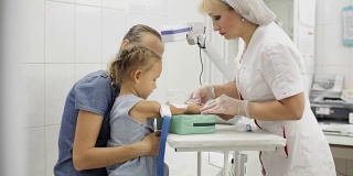 小女孩和妈妈住院了。护士给女孩取静脉血检查