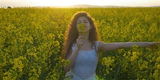 慢镜头里的年轻女子穿着白衣在满是油菜花的田野里翩翩起舞，散发着大自然的气息