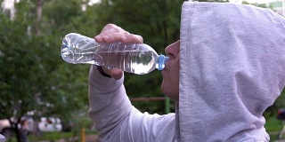 年轻人在健身跑步后喝水