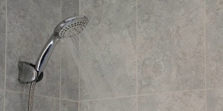 Shower faucet open expelling water in a bath