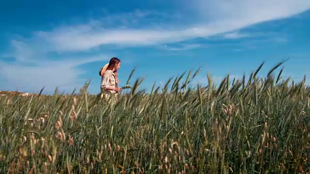 女农业场主在未成熟的麦田里行走