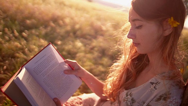 女孩在乡村的草地上看书