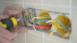 电工双手安装电线插头到墙上视频素材模板下载
