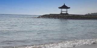 温暖的海浪在热带度假村的沙滩上奔跑，慢镜头
