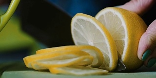 从一个躺在桌子上的柠檬上切下一把刀。