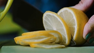 从一个躺在桌子上的柠檬上切下一把刀。视频素材模板下载