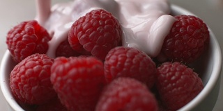 酸奶倒在新鲜的树莓上