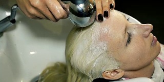发型师在美容院用洗发水洗头