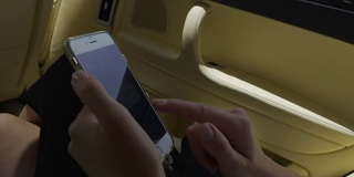 女性的手在智能手机上查看电子邮件，女性在出租车上，触屏