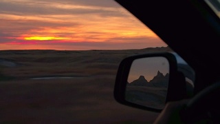 FPV:在令人惊叹的红色日落穿过荒地国家公园沙漠的公路旅行视频素材模板下载