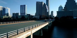 德克萨斯州奥斯汀阳光明媚的早晨靠近国会桥，早上骑自行车的人和汽车在上班的路上
